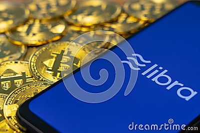 Bitcoin Coin with the Facebook`s Libra Crypto Coin logo Editorial Stock Photo