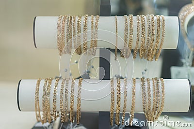 Gold bracelets in the display window of a jewelleries store in gold bazaar. Gold bracelets on the wind in the store Stock Photo
