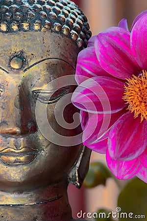 Gold buddha head statue and flower. Spiritual meditation and Zen buddhism nature image Stock Photo