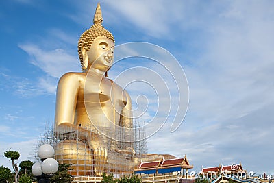 Gold buddha statue under construction in Thai temple with clear sky.WAT MUANG, Ang Thong, THAILAND. Stock Photo