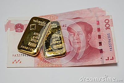 Gold bullion bars and Chinese Yuan renminbi banknotes, paper money and currency. Bank of China reserves Stock Photo