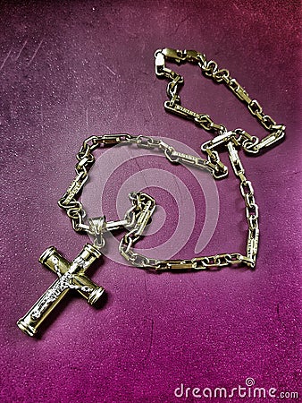 gold chain with a golden cross on a violet background Stock Photo