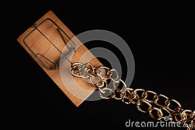 Gold chain in a mousetrap. Concept photo of a bait for greedy. Protection of values Stock Photo