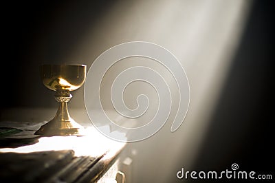 Gold chalice in altar with a ray of divine light Stock Photo