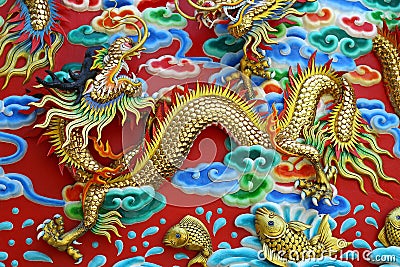 Gold chinese dragon statue at the wall of chinese temple in Thai Stock Photo