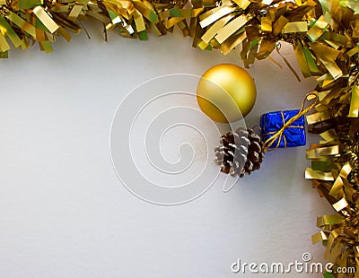 Gold Christmas ornament flat composition on white board. Golden ribbon. Stock Photo