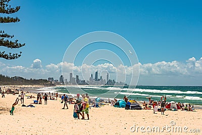 People relaxing on Burleigh beach with view of Gold Coast skyscrapers Editorial Stock Photo