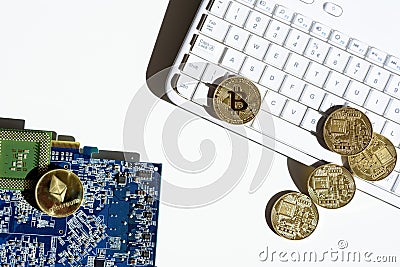 Gold coins with bitcoin and ethereum symbol lying on white computer keyboard and graphic card. Mining virtual crypto currency Editorial Stock Photo