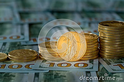 Gold coins stacked on new design 100 dollar bills Stock Photo