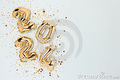 2024 gold colored inflatable balloons and shiny stars confetti. Stock Photo