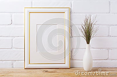 Gold decorated frame mockup with dark grass in elegant vase Stock Photo