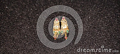 Gold earrings one pears background dork Stock Photo