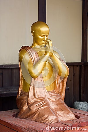 Gold figure of the praying monk Stock Photo