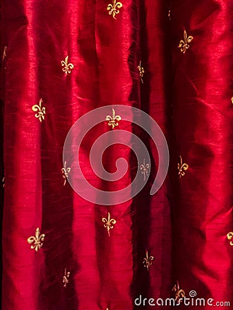 Gold fleur de lis on red silk curtains Stock Photo