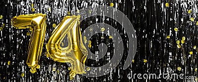 Gold foil balloon number number 74 on a background of black tinsel decoration. Birthday greeting card, inscription Stock Photo
