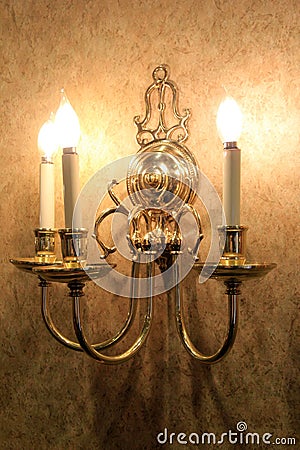 Gold foil wallpaper with beautiful candle-like lighting fixture Stock Photo