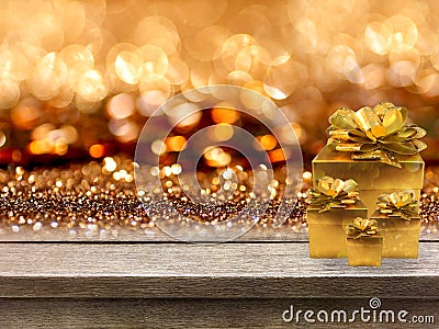 Gold gift boxes and ribbon on wood table, bokeh background Stock Photo