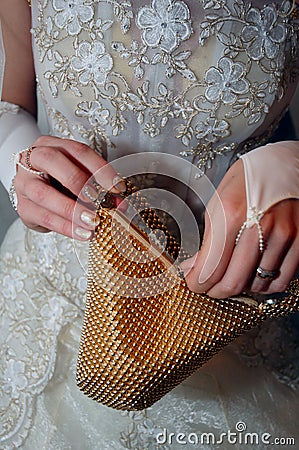 Gold handbag in bride hands Stock Photo