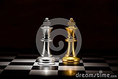 gold king chess facing silver king chess on chess board , business strategy concept Stock Photo