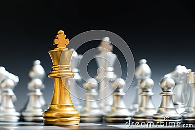 Gold king chess piece face another silver team on black background Stock Photo