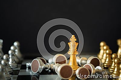 Gold king chess stands on chessboard surrounding with opponents on dark background Stock Photo