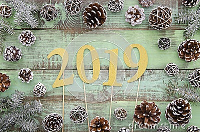 2019 gold letters on green wooden plank table background with pine cones and knitter scarf, 2019 new year greeting card Stock Photo