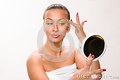 Gold make up. Brown sleek hair beautiful woman looking at mirror Stock Photo