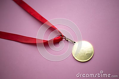 gold medal on a red ribbon on a pink background Stock Photo