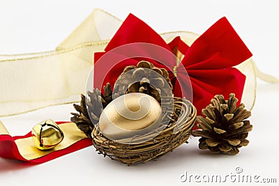 Gold nest egg with pine cones and ribbons Stock Photo