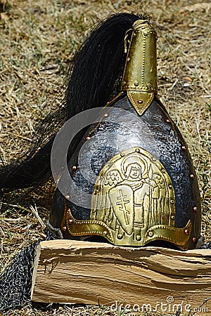 Gold plated decorative medieval conical helmet with black ponytail comb and embossed slavic christian motives Stock Photo