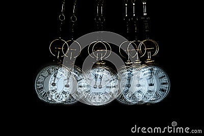 Gold Pocket watch swinging hypnotically from chain. Black background Stock Photo