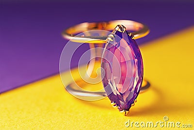 Gold ring with a large amethyst on a colored background Stock Photo
