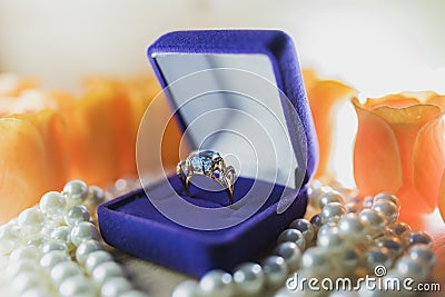 Gold ring with topaz in a gift box on pearls Stock Photo