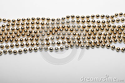 Gold round beads garland on white backgroun. Flat lay. Top view Stock Photo