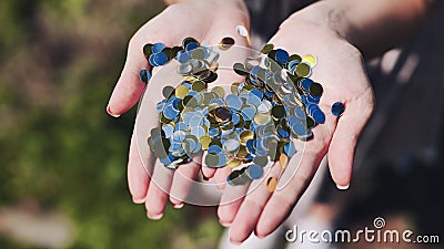 Gold and silver mirrored confetti in the girl& x27;s hands. Stock Photo