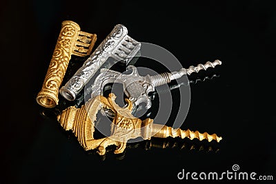 Gold and silver vintage corkscrews in the form of a key on a black background Stock Photo