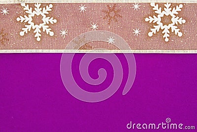 Gold snowflake ribbon on bright purple textured felt material background Stock Photo