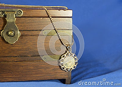 Gold sovereign coin as woman pendant on wooden present box Stock Photo