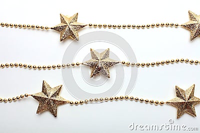 Gold star and bead garland on white backgroun. Flat lay. Top view Stock Photo