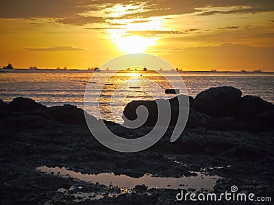 Gold sun light and stone seaside in Thailand Stock Photo