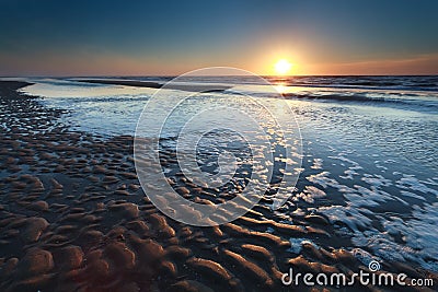 Gold sunset over North sea sand beach at low tide Stock Photo