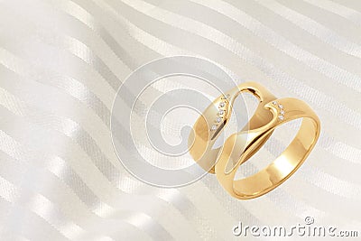 Gold wedding rings on golden festive background Stock Photo