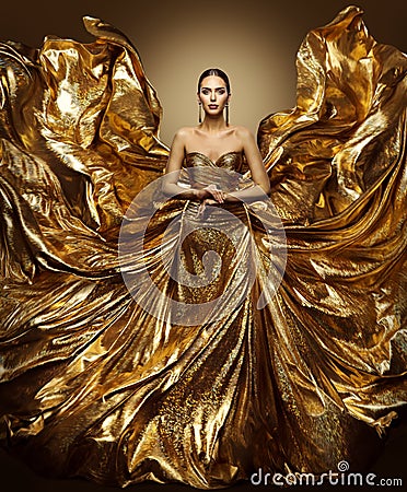 Gold woman flying dress, fashion model in waving art golden gown Stock Photo
