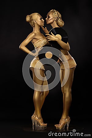 Futurism. Creativity. Glossy Golden Women with Vinyl Record over Black. Shiny Gilded Bodyart Stock Photo