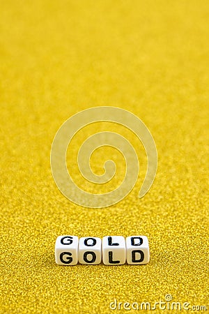 Gold word formed by white dices with black letters laying on golden background Stock Photo