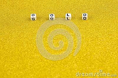 Gold word formed by white dices with black letters laying on golden background Stock Photo