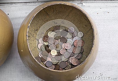 Golden alms bowls with little thai coins in buddhist temple Stock Photo