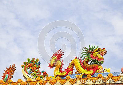 Golden artistic grand yellow Asian dragon statue on the roof of a temple Stock Photo