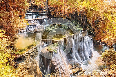 Golden autumn waterfall flowing in tropical rainforest Stock Photo