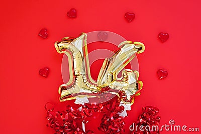 Golden 14 balloons souvenir heart isolated on red background. Helium balloons gold foil numbers. Stock Photo